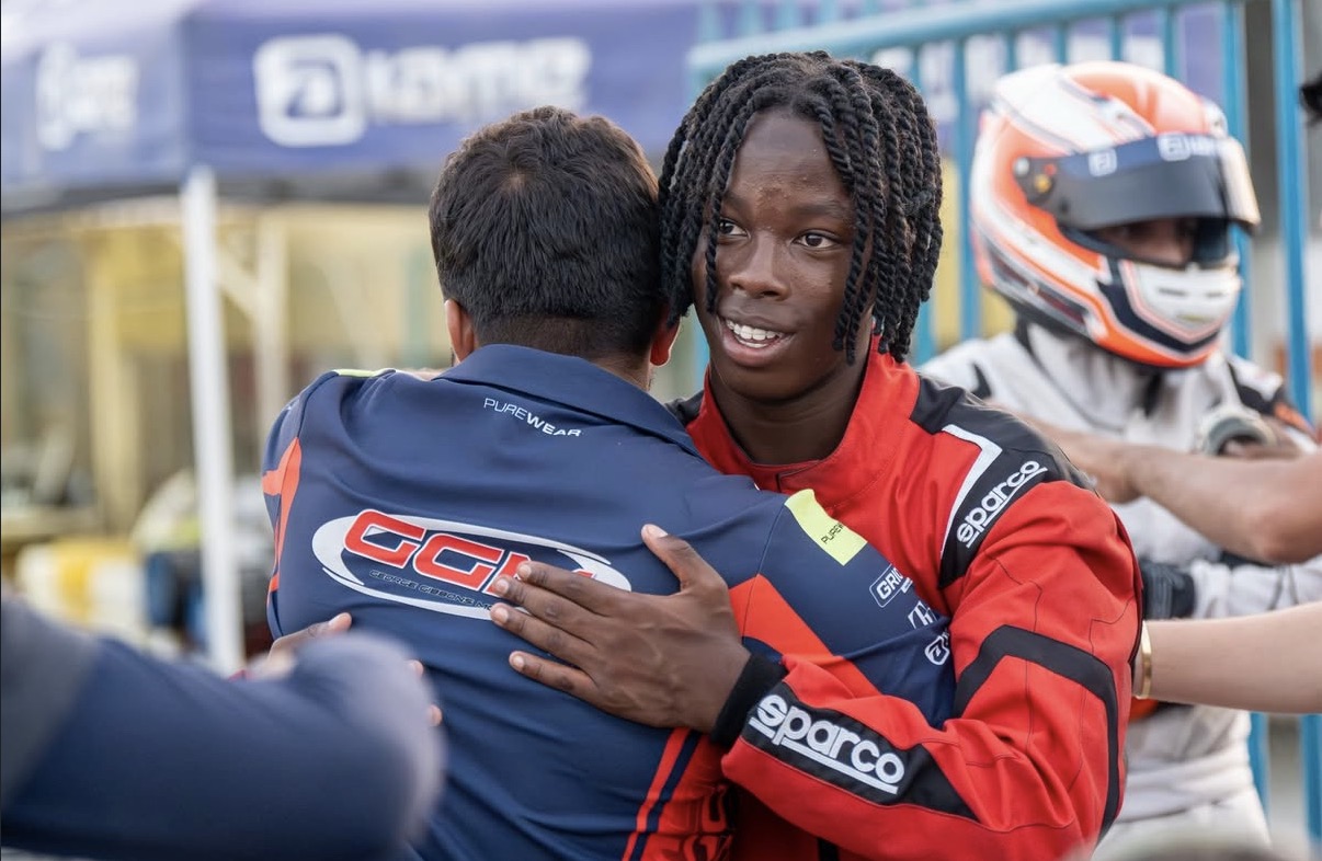 Amani celebrating with his team in the pits
