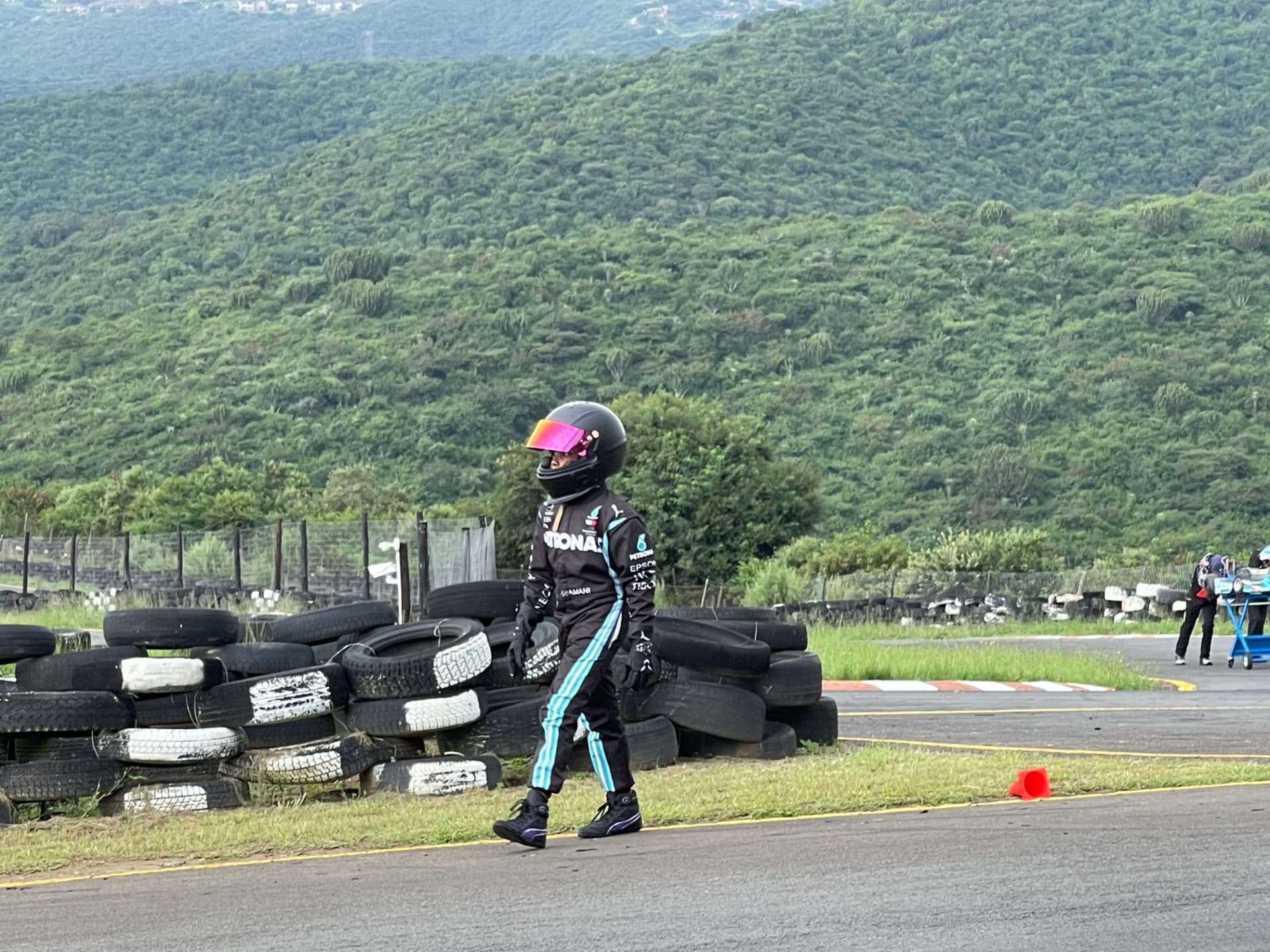 Amani walking the track past stacked tyres